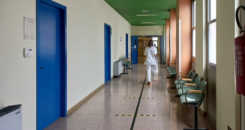 Hoitaja kävelee terveyskeskuksen käytävällä.