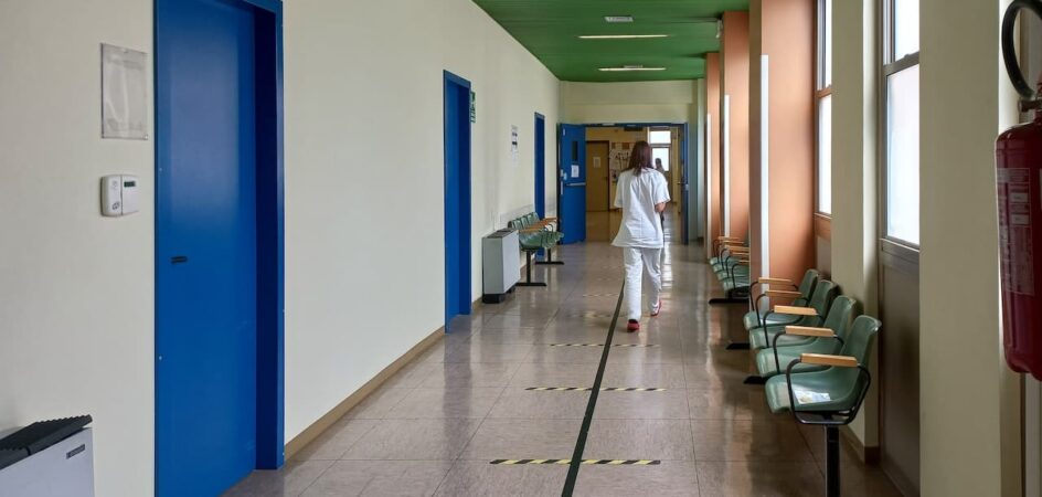Hoitaja kävelee terveyskeskuksen käytävällä.