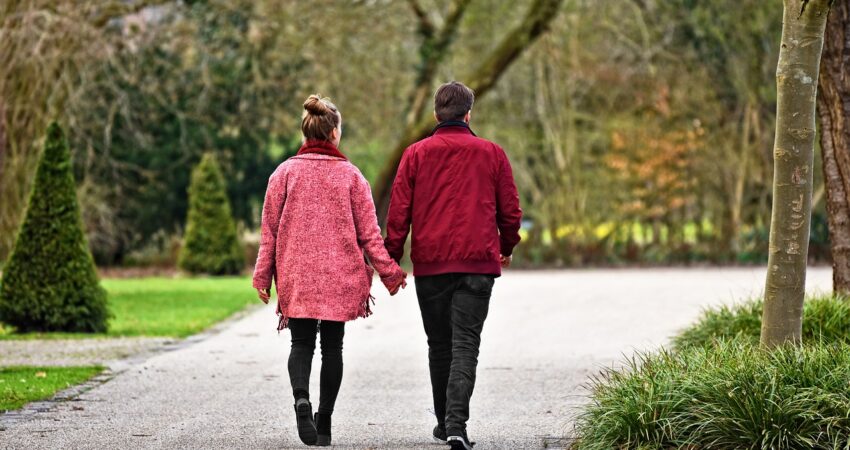 Nainen ja mies kävelee käsi kädessä.
