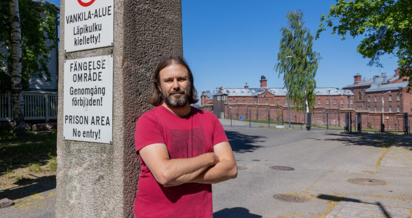 Tutkija Teemu Kaskela A-klinikkasäätiöltä nojaa vankilna portin pieleen