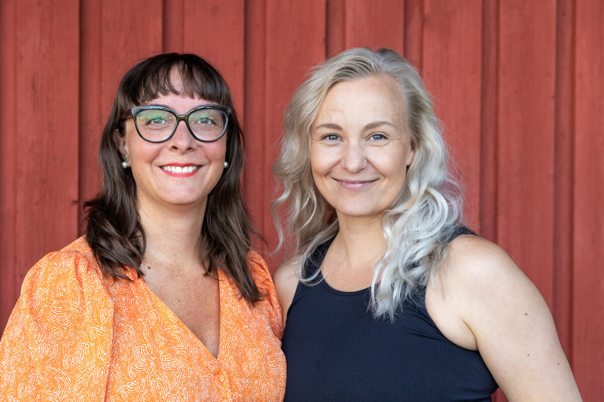 Psykologian tohtori, erikoispsykologi ja psykoterapeutti Vera Gergov ja näyttelijä Elina Aalto yhteiskuvassa katsovat kameraan punaisen seinän edessä