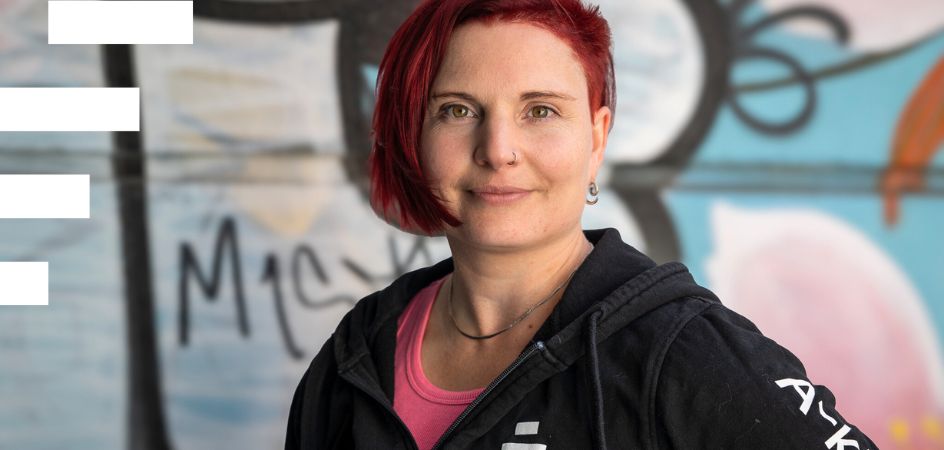 A-klinikkasäätiön Kohtaavan työn päällikkö Annuska Dal Maso katsoo kameraan graffitiseinän edessä