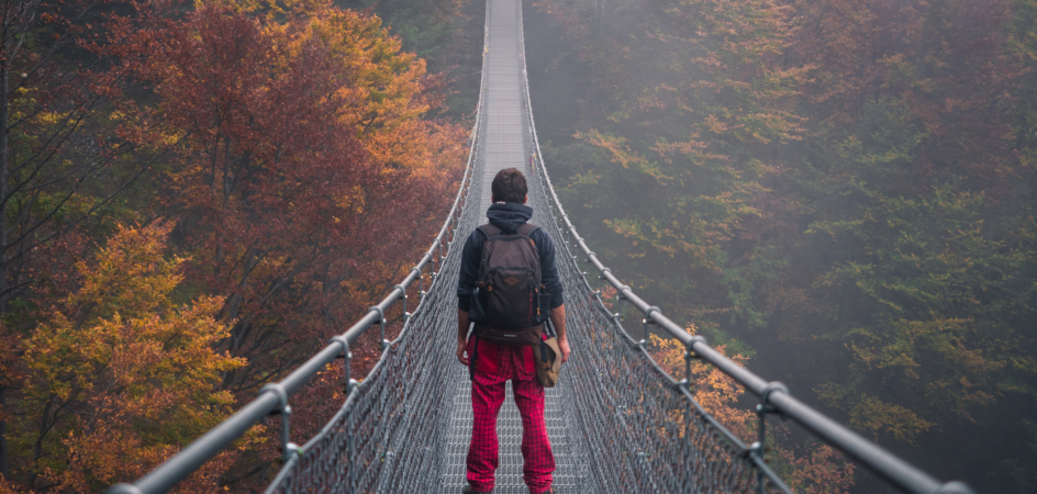 Mies seisoo riippusillalla, selkä päin kameraa.