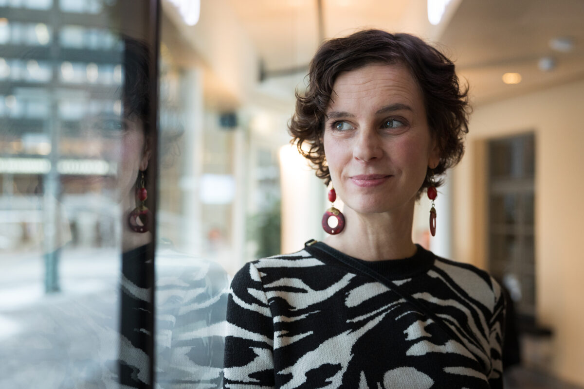 Kuvassa Olga Temonen katsoo ikkunasta ulos