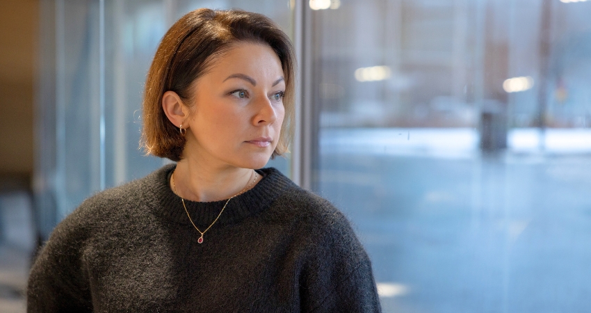 Kuvassa nainen katsoo ulos ikkunasta