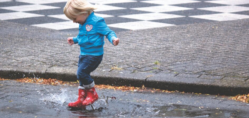 Lapsi leikkii vesilammikossa.