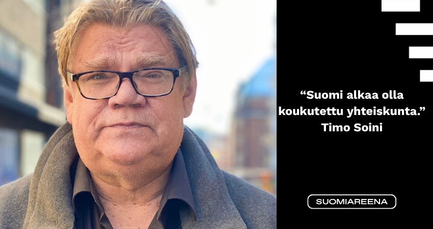 Kuvassa Timo Soini katukuvassa katsoo suoraan kameraan.