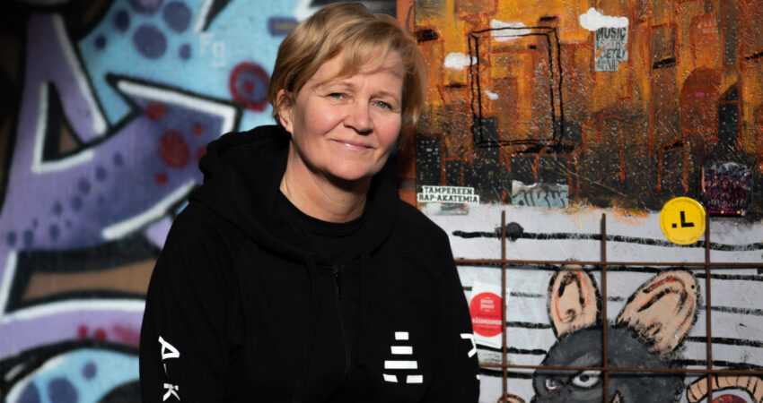 Kuvassa vaaleahiuksinen henkilö, jolla on musta huppari. Hupparissa lukee A-klinikkasäätiö.