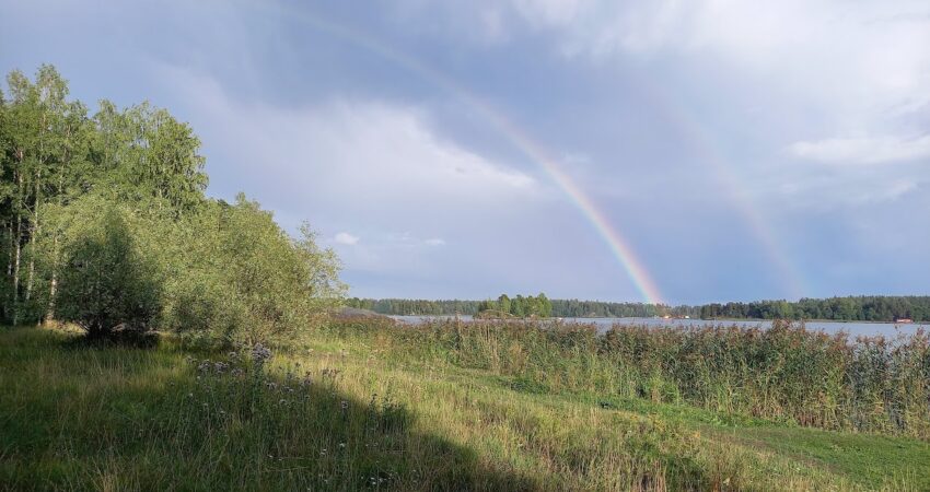 kesäinen merenranta maisema ja sateenkaari
