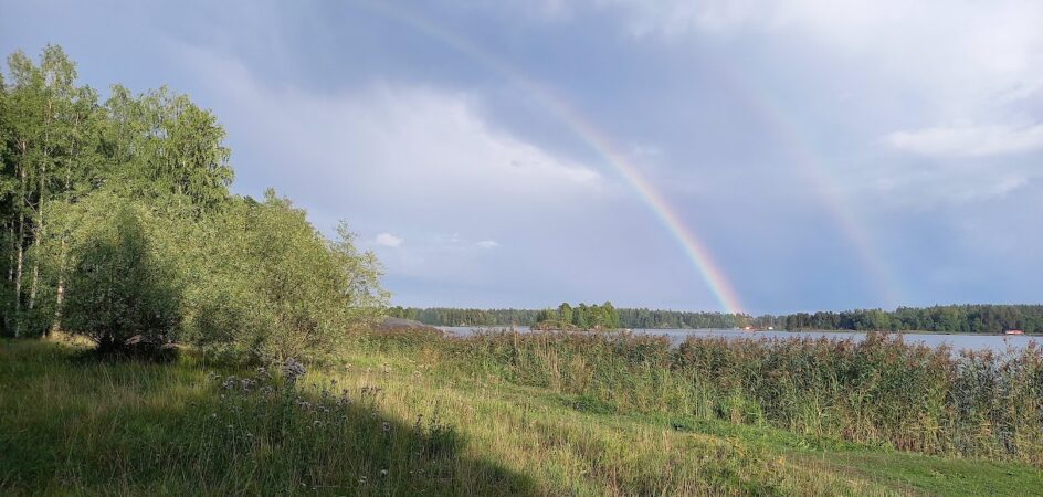 kesäinen merenranta maisema ja sateenkaari