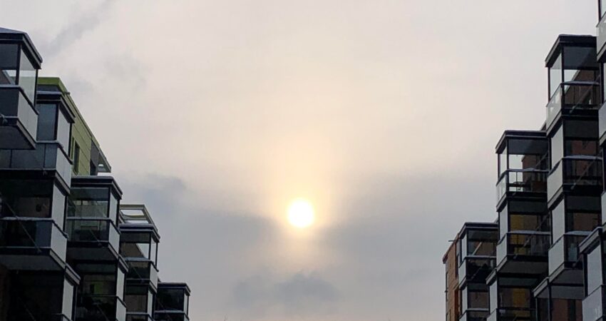 aurinko paistaa kerrostalojen välistä talvellla