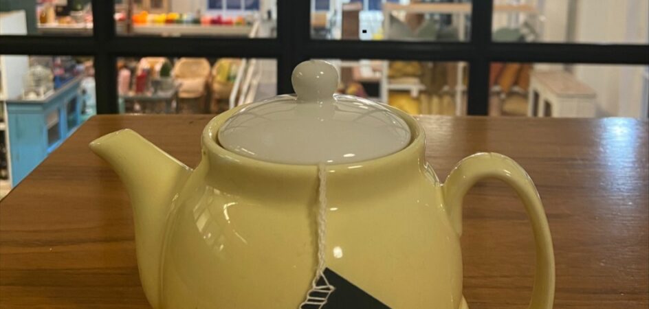 Keltainen teepannu kahvilan pöydällä