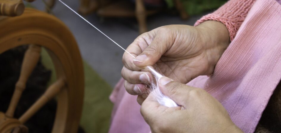 Kädet kehräämässä lankaa rukilla