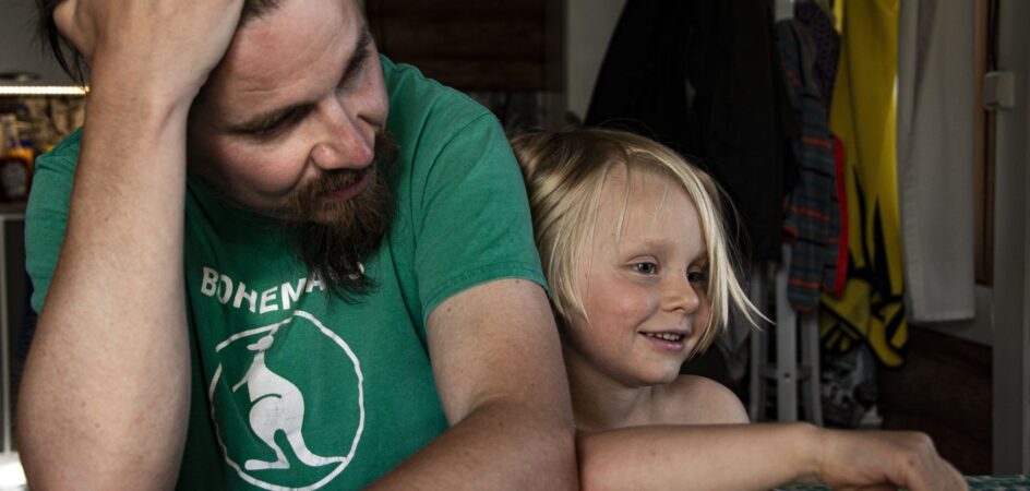 Isä ja lapsi pöydän ääressä pelaamassa Unoa